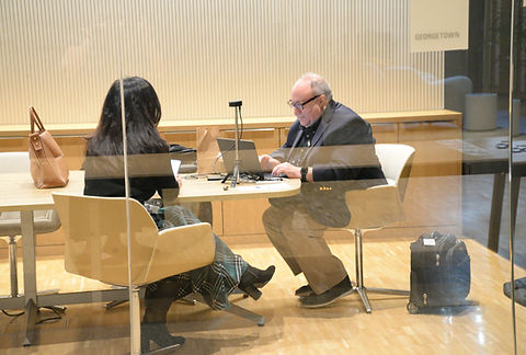 Two attendees seated at a table with laptops