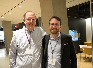 Two attendees with name badges posing together