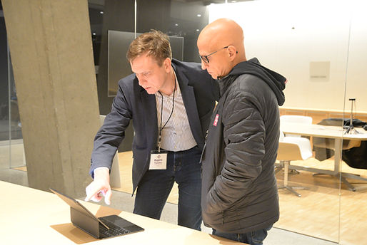 Two attendees looking at a laptop together